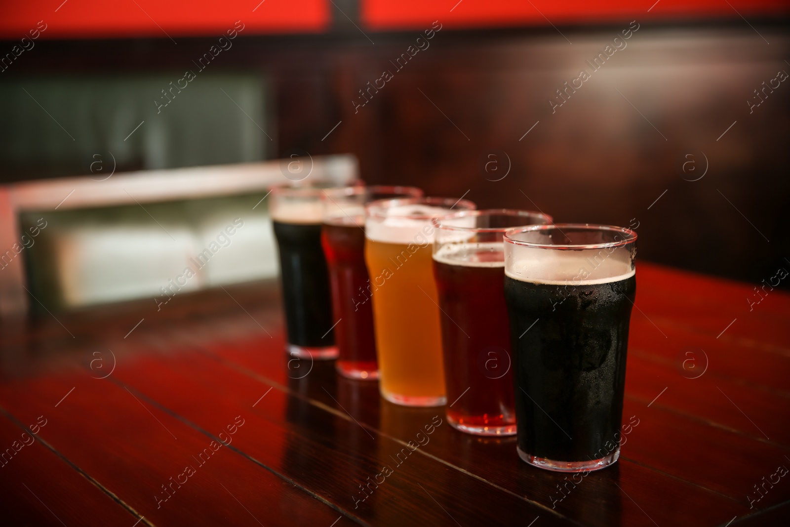 Photo of Glasses of different beer on table indoors