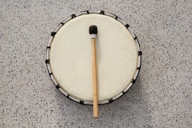 Photo of Drum and drumstick on grey table, top view. Percussion musical instrument