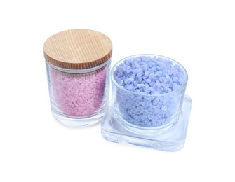 Photo of Glass containers of different sea salt isolated on white