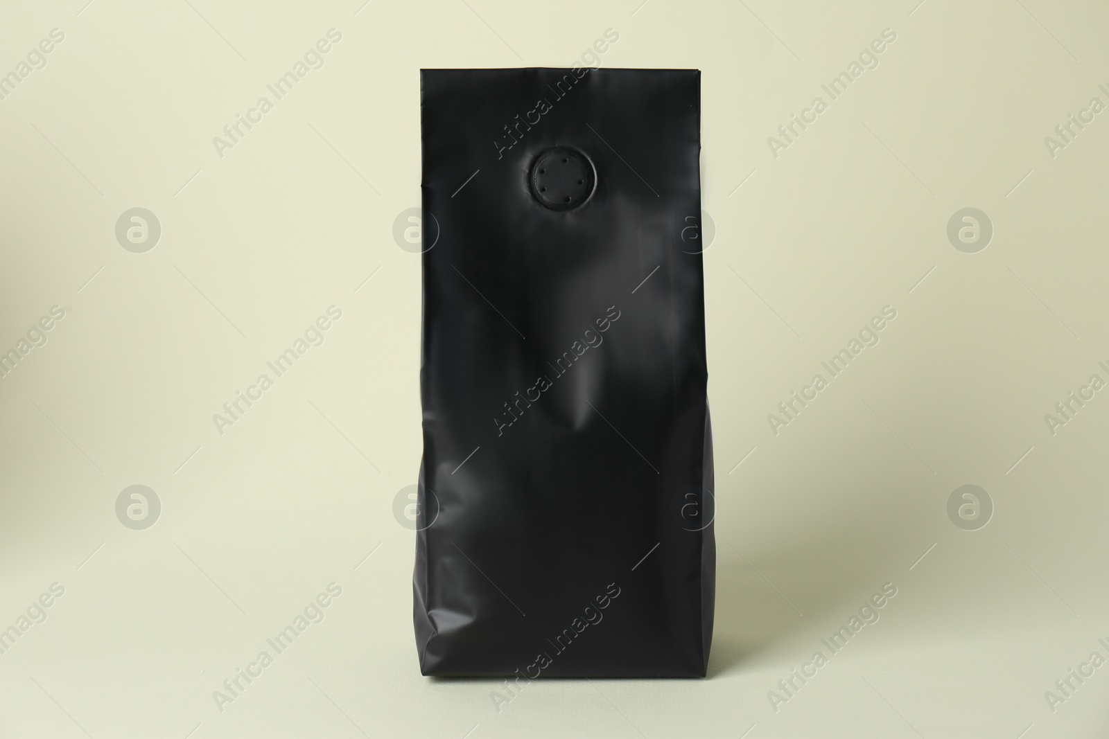 Photo of One blank foil package on beige background