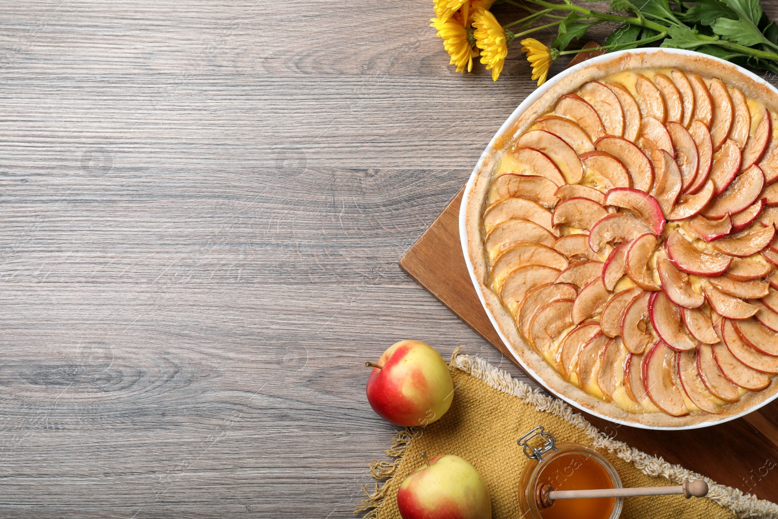 Photo of Flat lay composition with tasty apple pie on wooden table, space for text