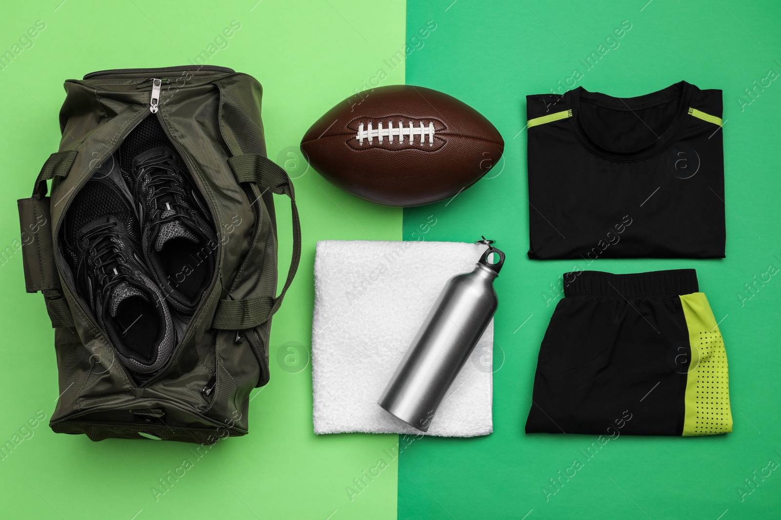 Photo of Gym bag and sports equipment on green background, flat lay