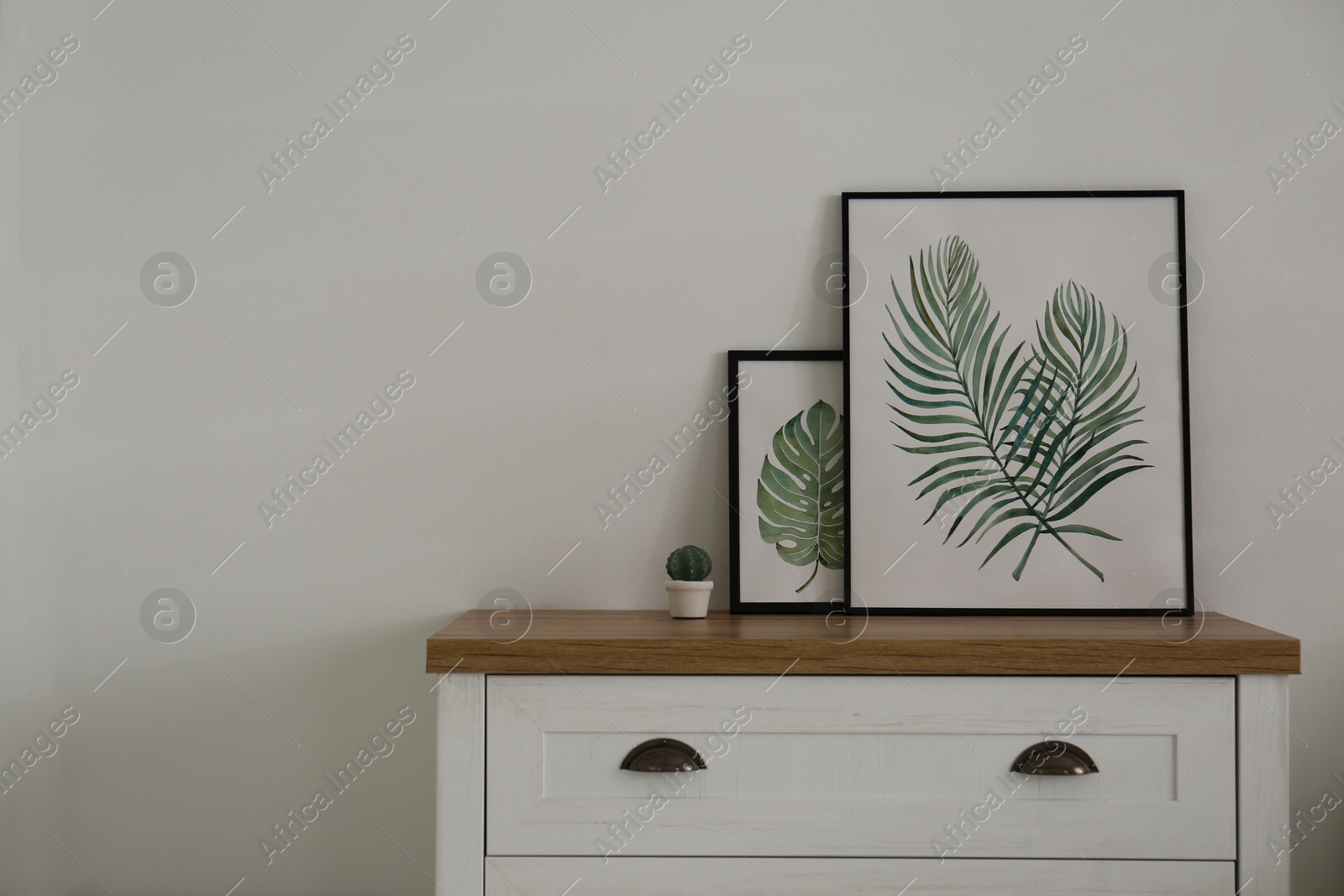 Photo of Modern chest of drawers with paintings in living room