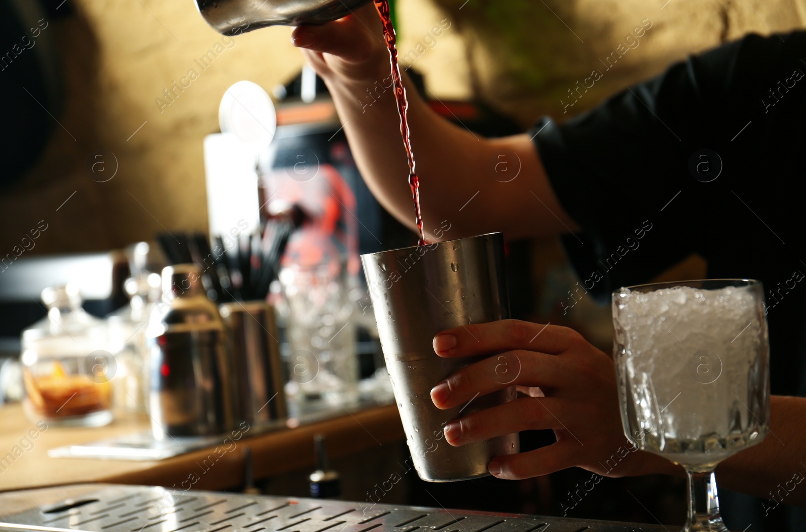 Photo of Bartender preparing fresh alcoholic cocktail at bar counter, closeup