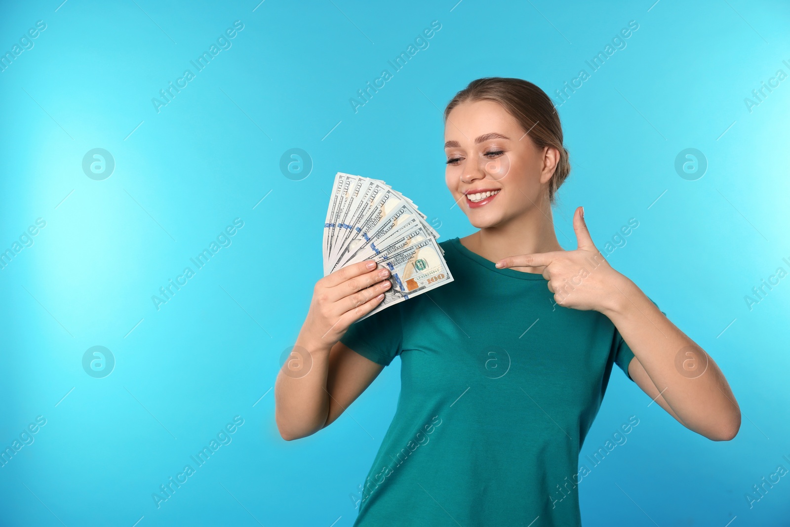 Photo of Portrait of happy young woman with money on color background. Space for text