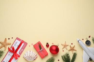 Photo of Flat lay composition with toy airplane, starfishes and space for text on yellow background. Christmas vacation