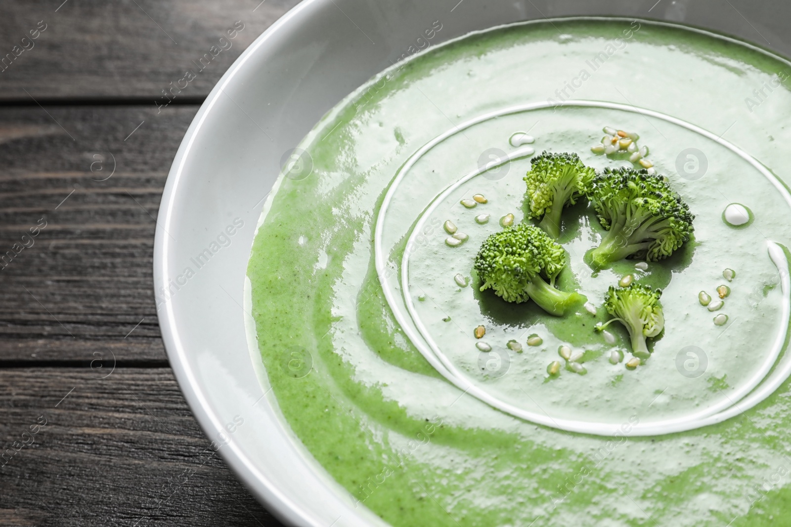 Photo of Fresh vegetable detox soup made of broccoli in dish on table, closeup