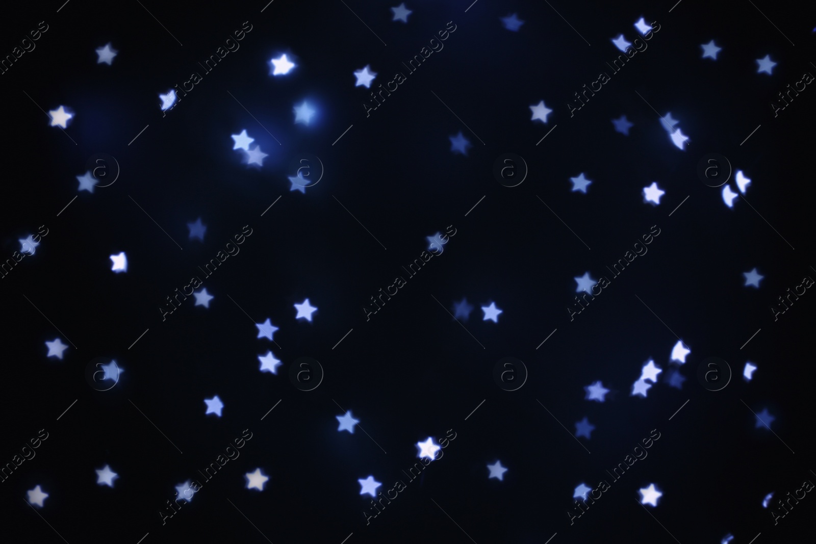 Photo of Beautiful star shaped lights on black background, space for text