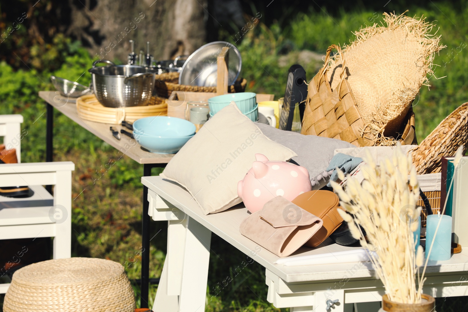 Photo of Small tables with many different items on garage sale outdoors