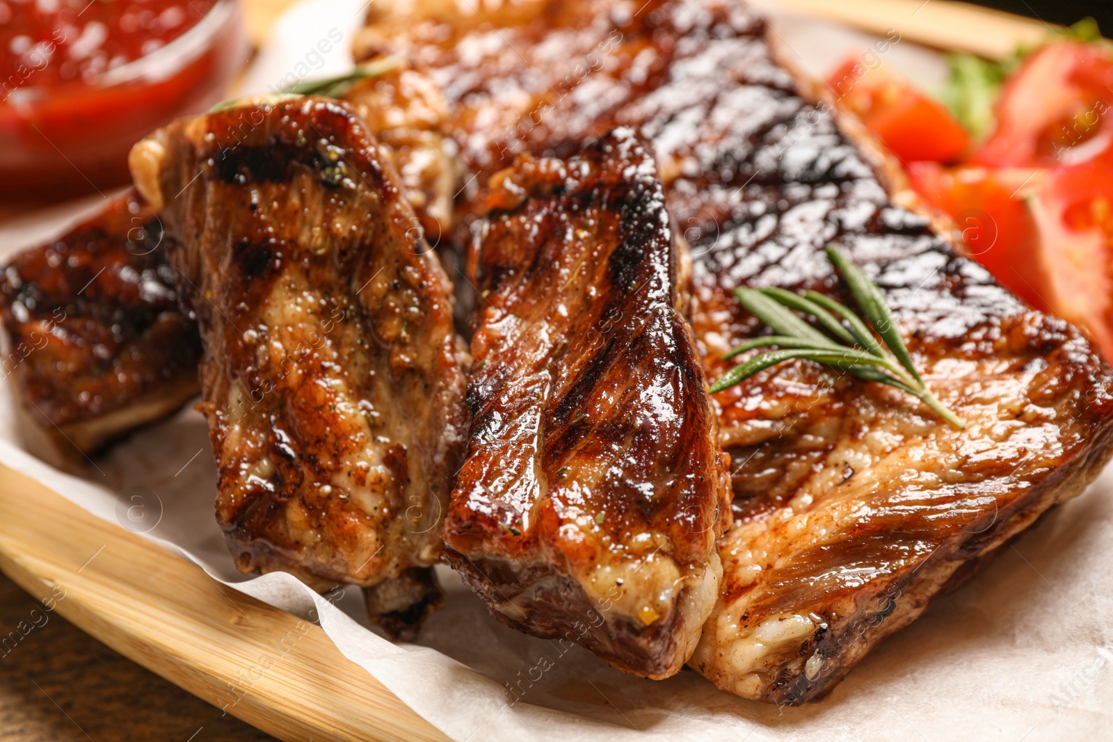 Photo of Delicious grilled ribs with rosemary on table, closeup