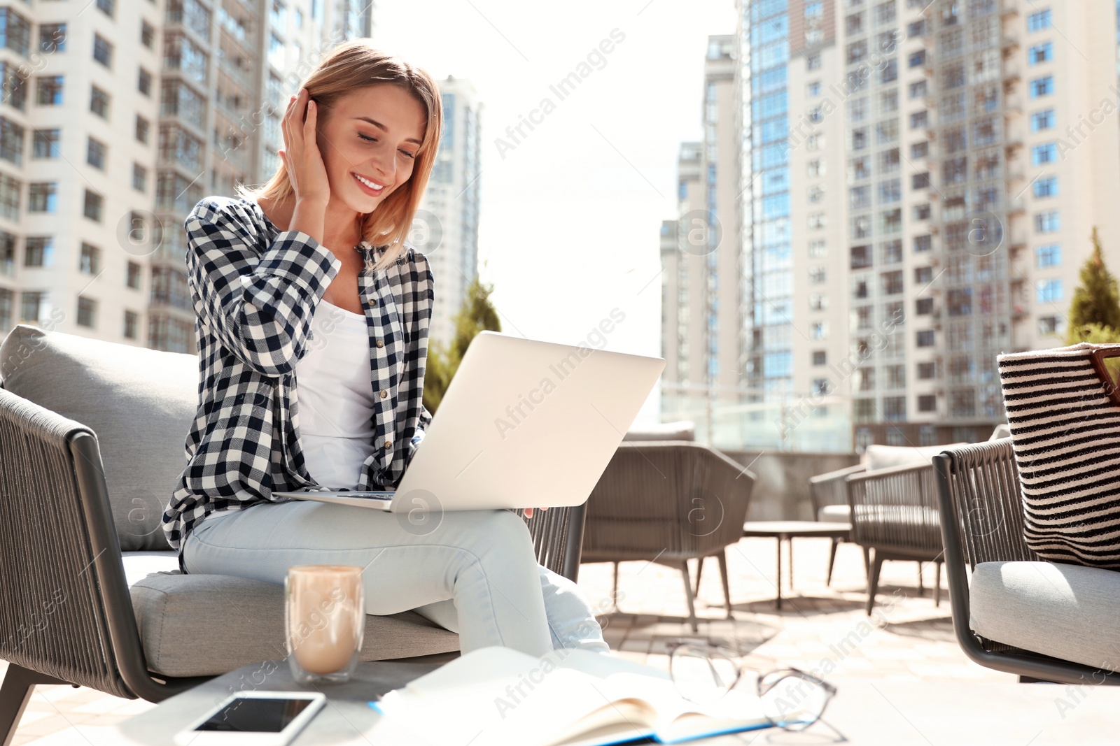 Photo of Beautiful woman using laptop at outdoor cafe