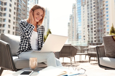 Beautiful woman using laptop at outdoor cafe