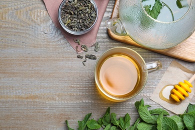 Photo of Flat lay composition with cup of hot aromatic mint tea on wooden table, space for text