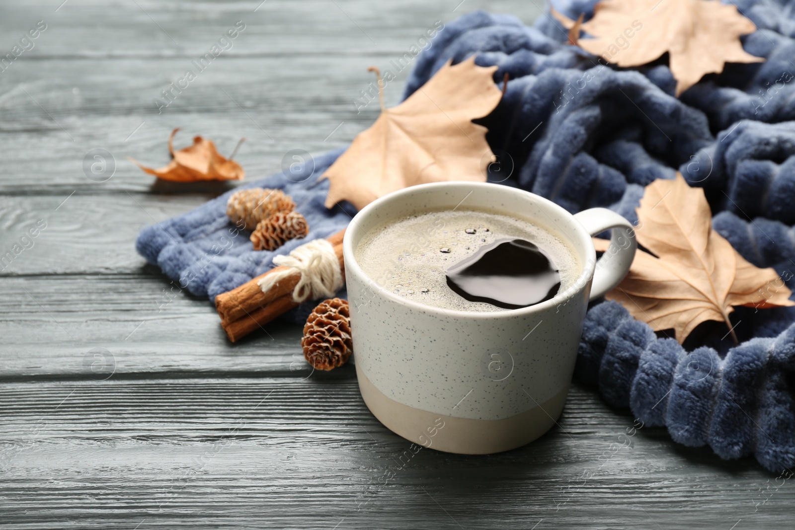 Photo of Composition with hot drink and warm plaid on black wooden table