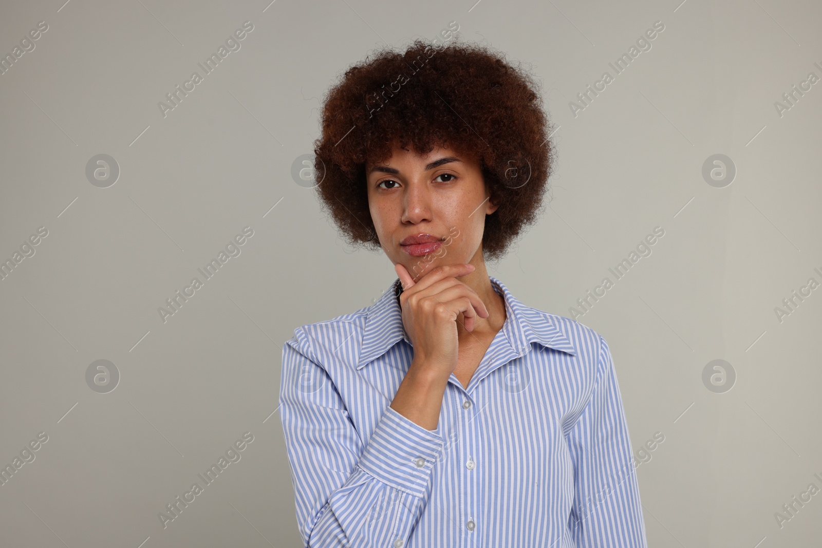 Photo of Portrait of thoughtful young woman on grey background