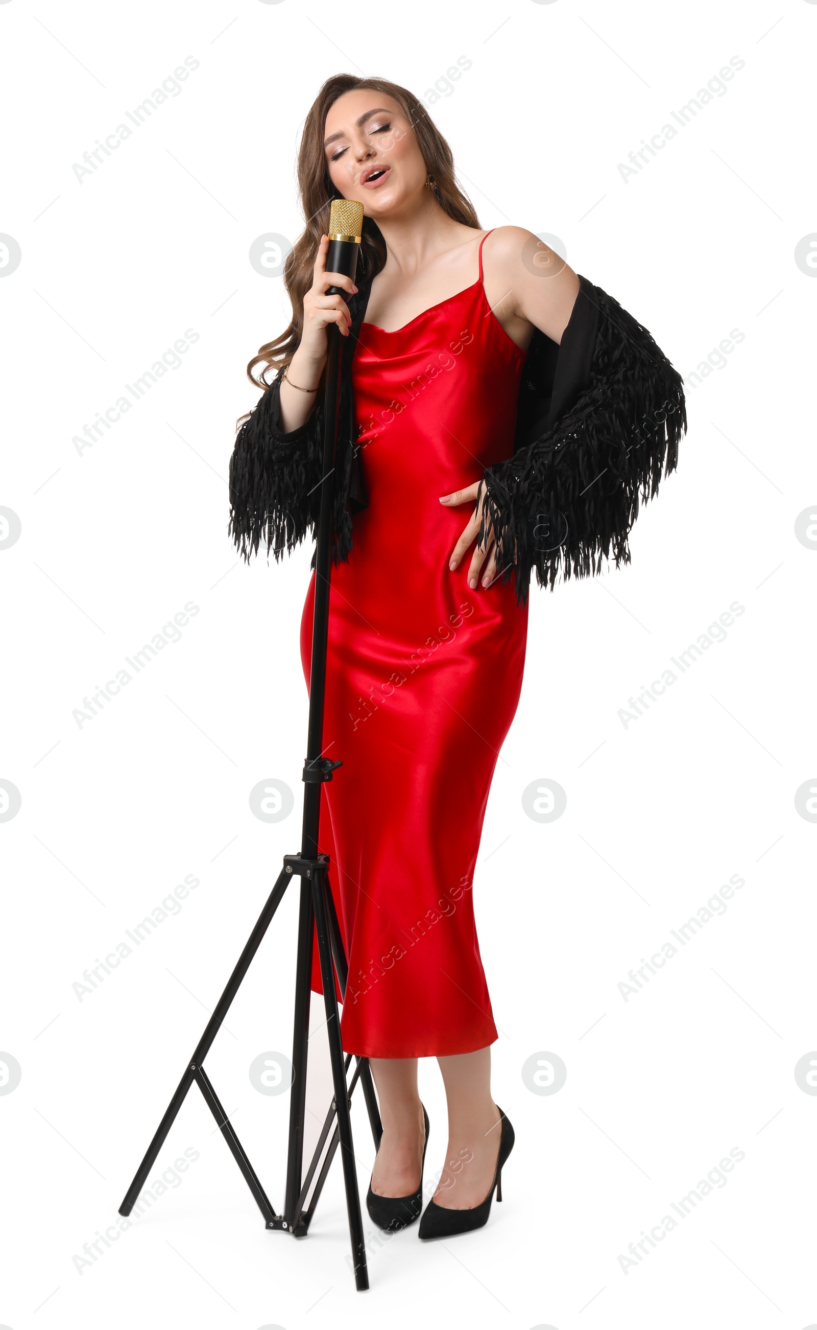 Photo of Beautiful young woman in stylish red dress with microphone singing on white background