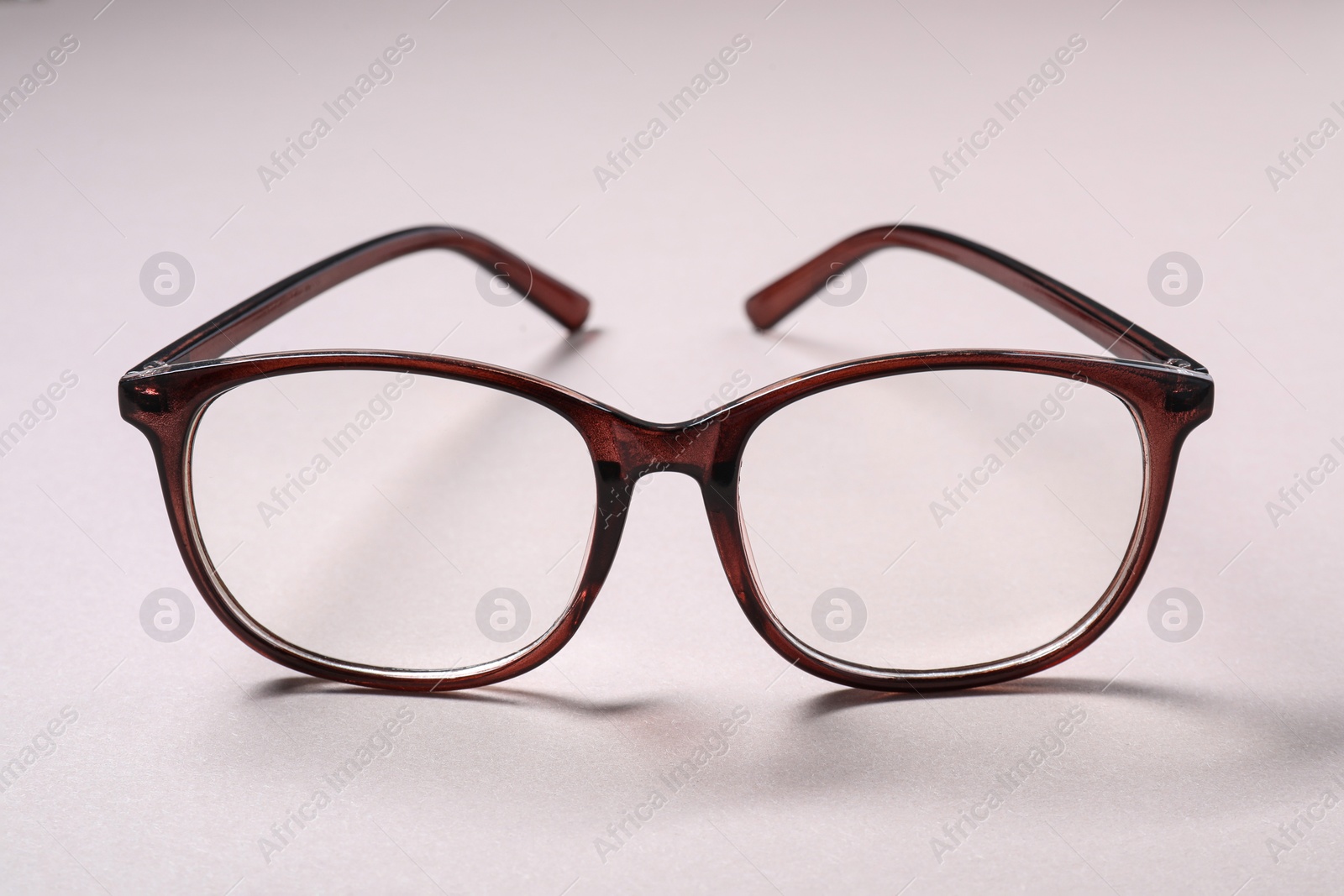 Photo of Stylish pair of glasses on light background, closeup