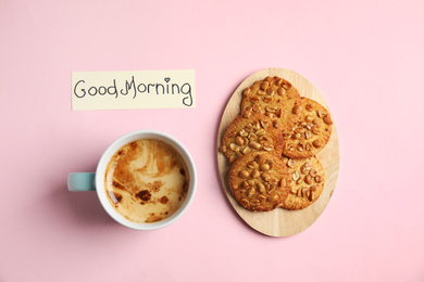 Photo of Delicious coffee, cookies and card with words GOOD MORNING on pink background, flat lay