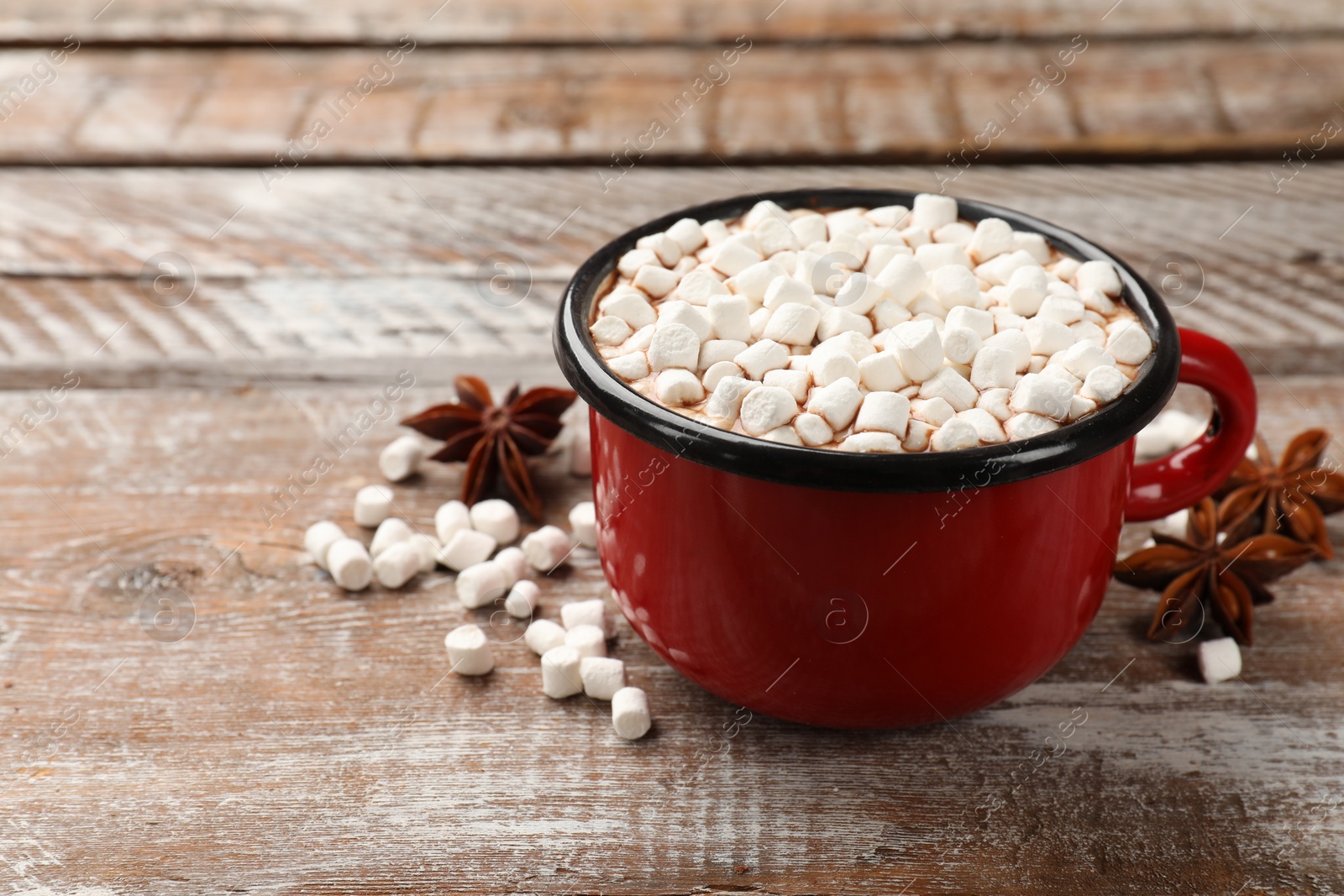 Photo of Tasty hot chocolate with marshmallows on wooden table, closeup. Space for text