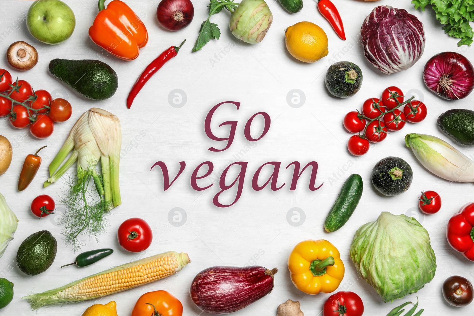 Image of Phrase Go Vegan and fresh vegetables on white background, flat lay