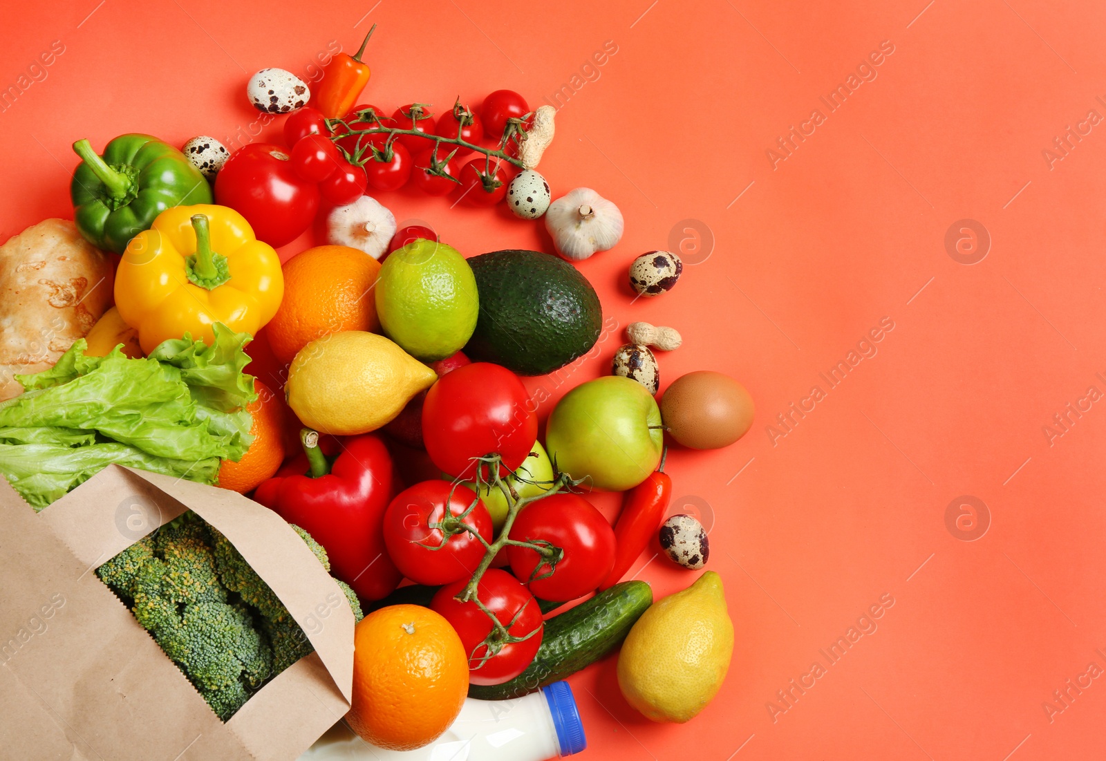 Photo of Paper bag with different groceries on coral background, flat lay. Space for text