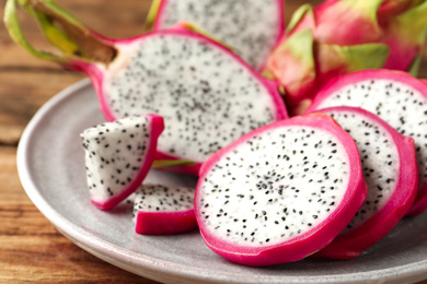 Photo of Delicious cut dragon fruit (pitahaya) on wooden table, closeup