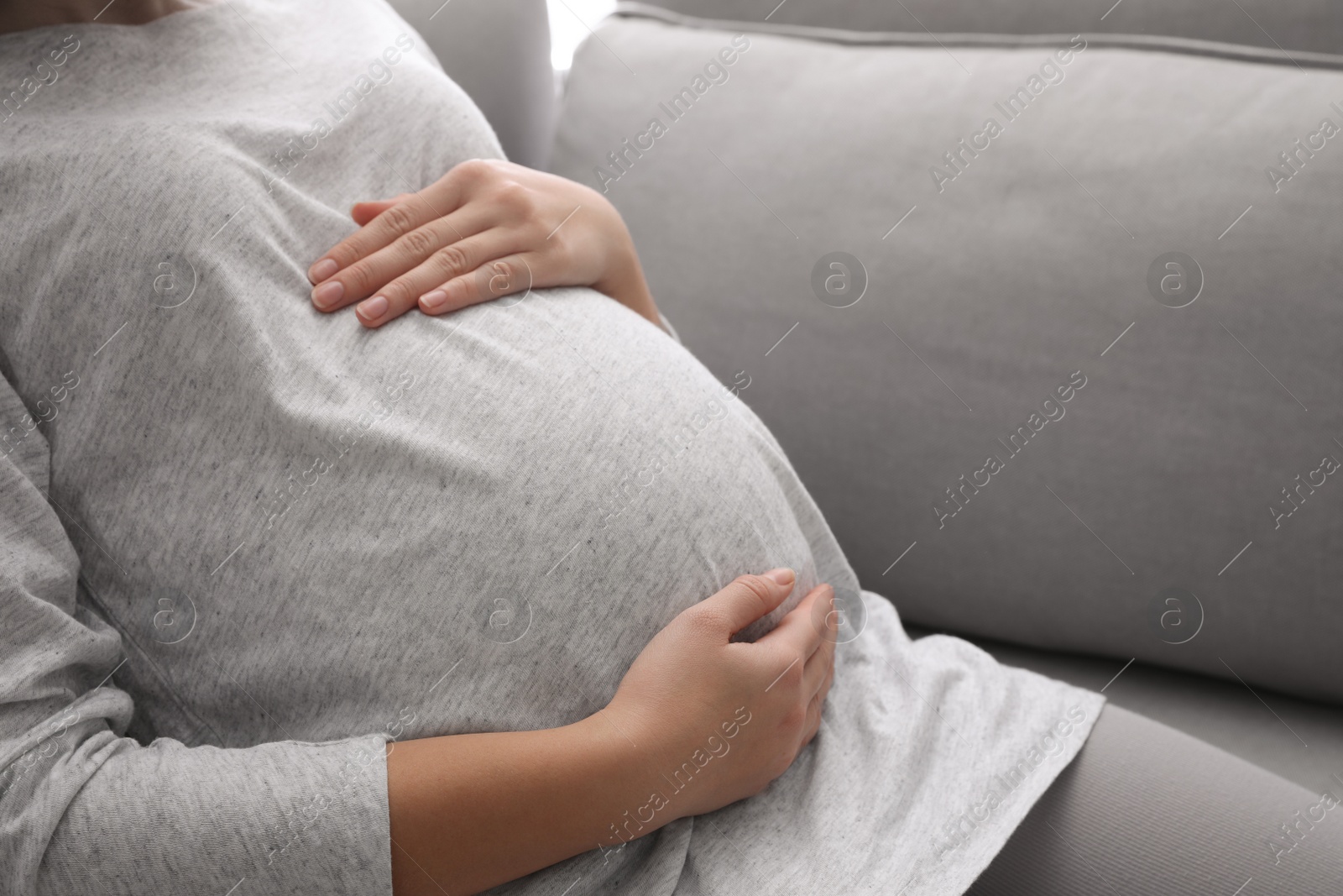 Photo of Pregnant woman resting on sofa, closeup view