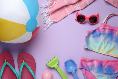 Photo of Frame of beach ball, toys and accessories on violet background, flat lay. Space for text