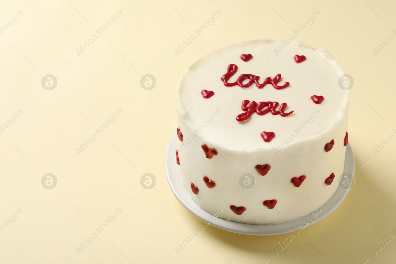 Photo of Bento cake with text Love You on beige table, space for text. St. Valentine's day surprise