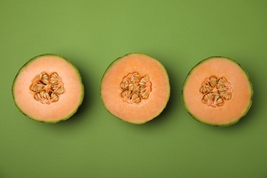 Photo of Cut melons on green background, flat lay