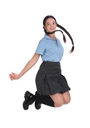 Teenage girl in school uniform jumping on white background