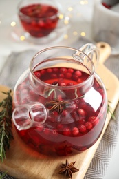 Photo of Tasty hot cranberry tea with rosemary and anise on table, closeup