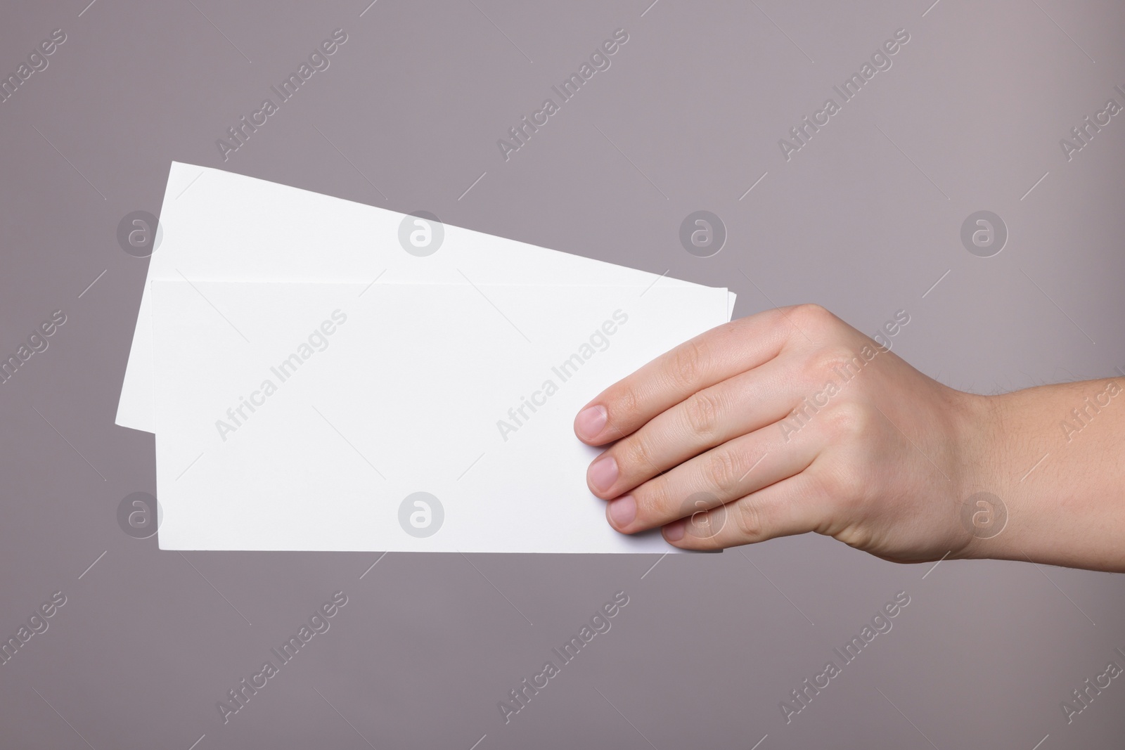 Photo of Woman holding flyers on grey background, closeup. Mockup for design