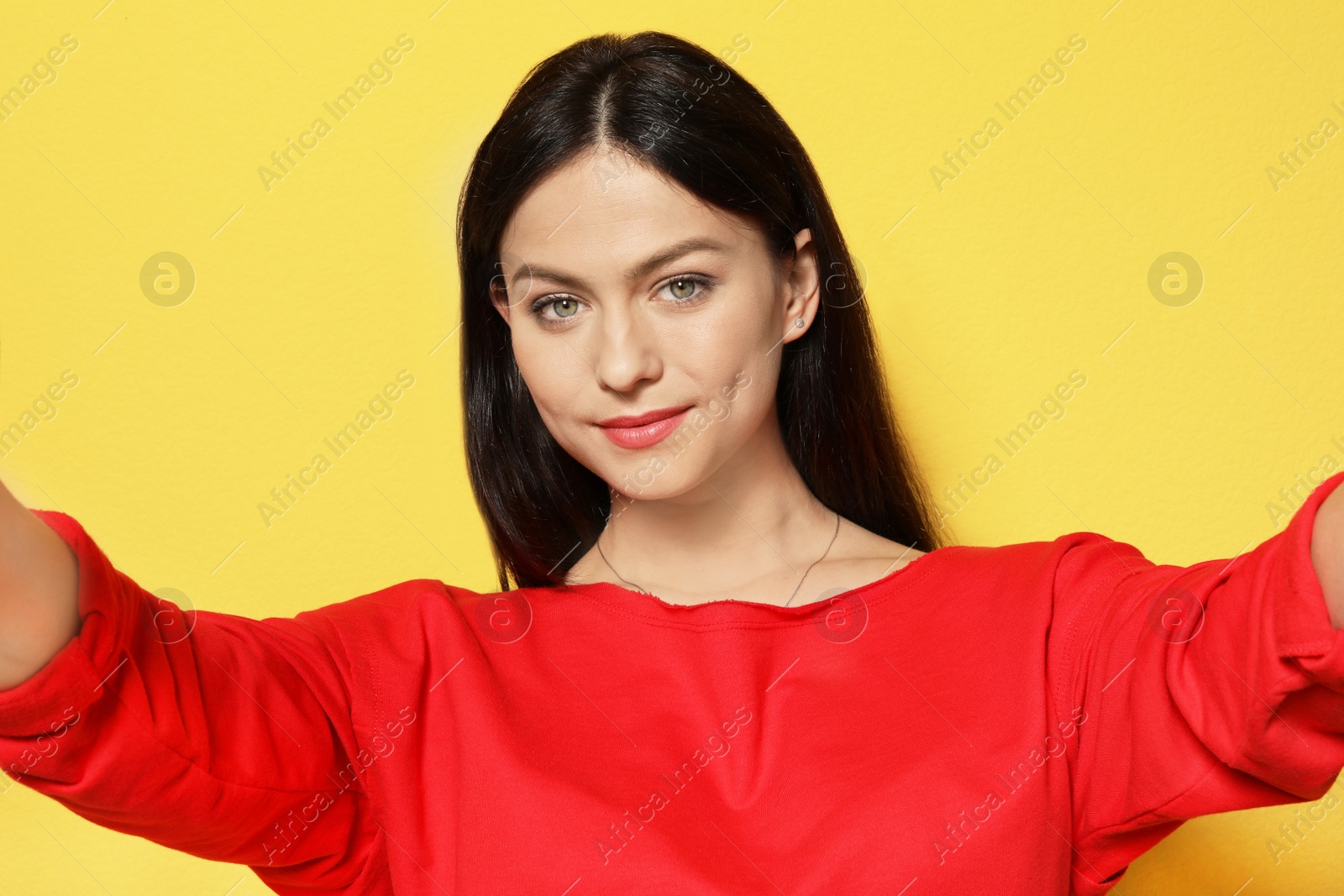 Photo of Attractive young woman taking selfie on color background