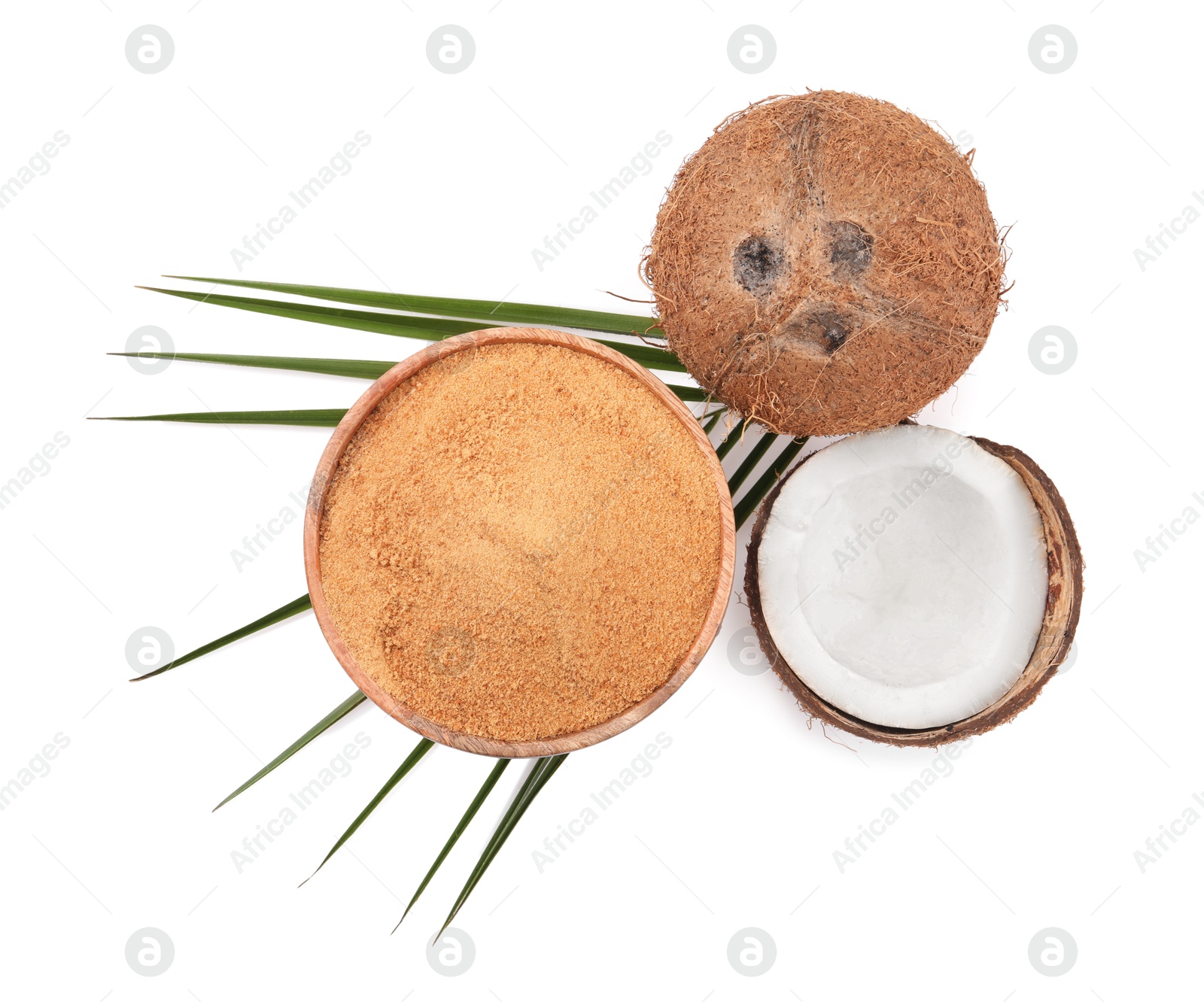 Photo of Coconut sugar in bowl, fruits and palm leaf isolated on white, top view