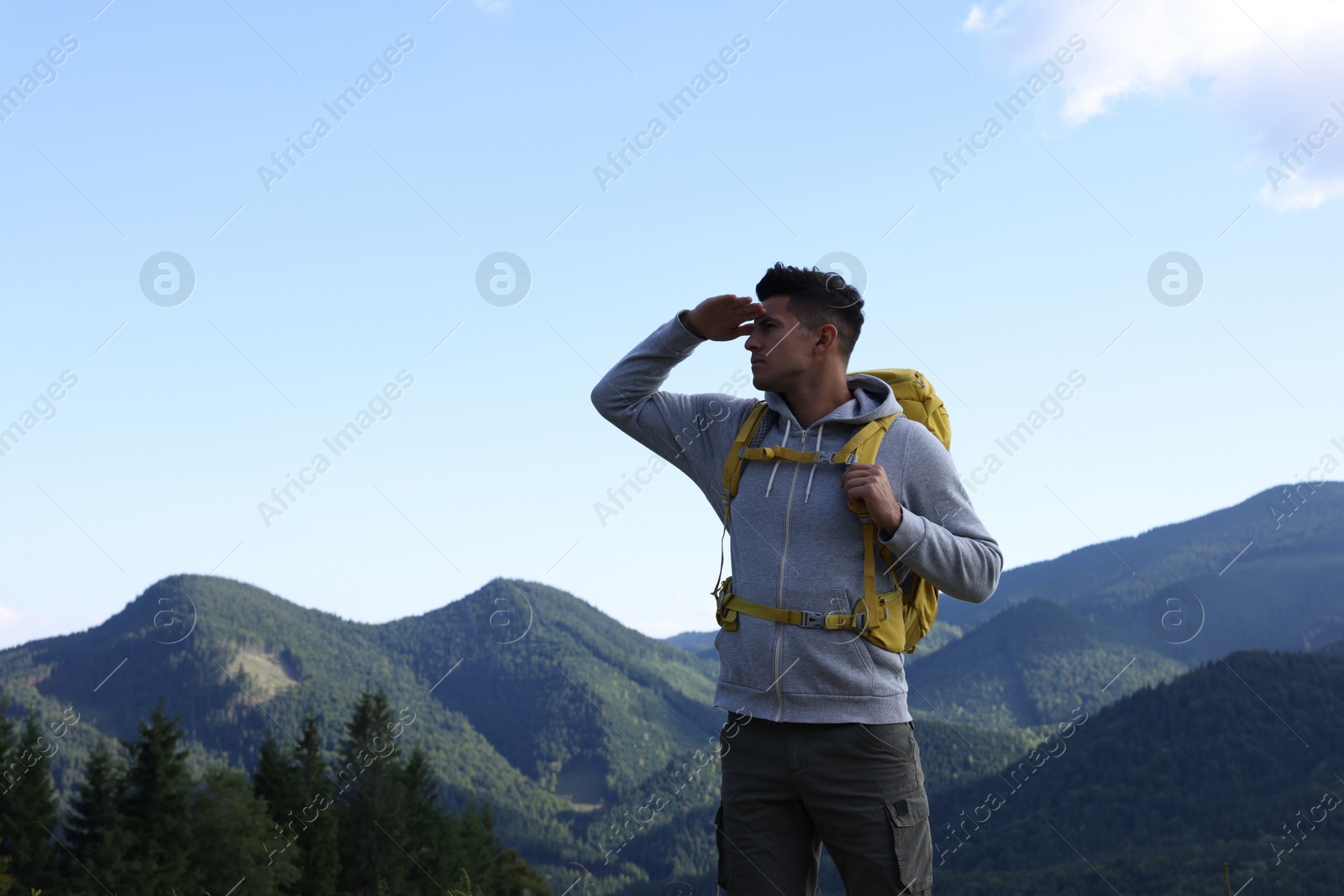 Photo of Tourist with backpack in mountains, space for text