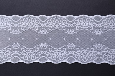 White lace on black background, top view