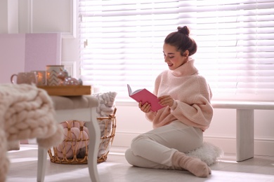 Photo of Beautiful young woman with book relaxing at home. Cozy atmosphere