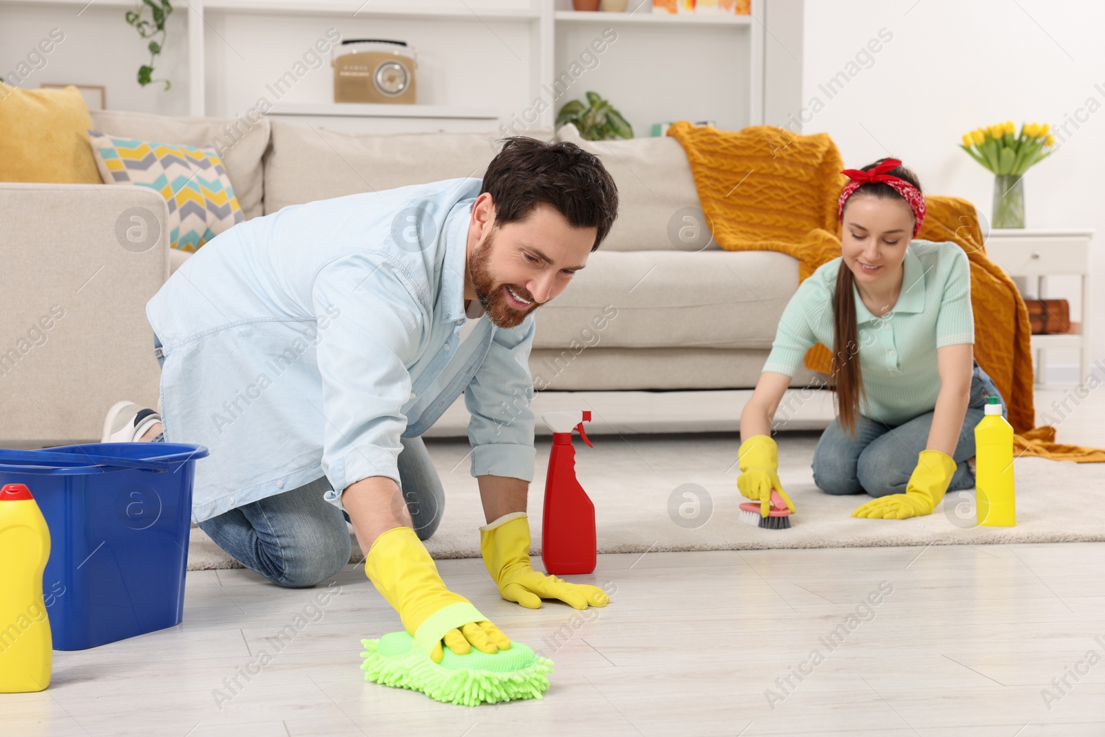 Photo of Spring cleaning. Couple tidying up living room together