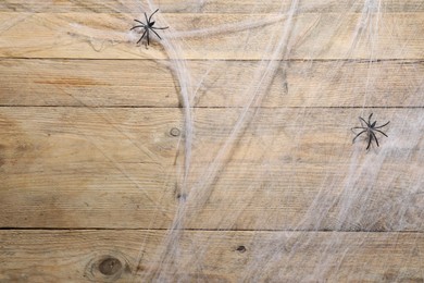 Cobweb and spiders on wooden surface, top view. Space for text
