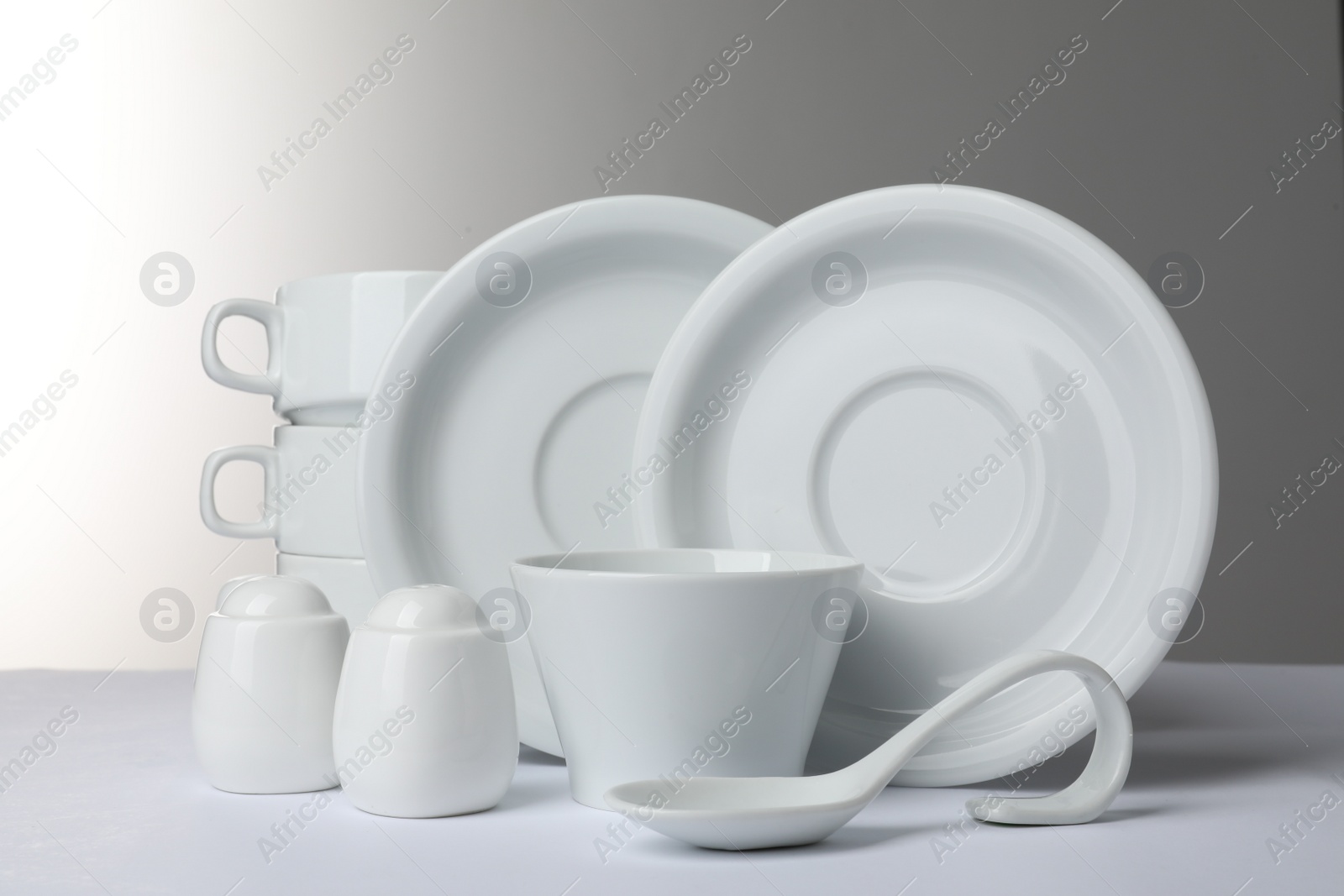 Photo of Set of clean dishware isolated on white