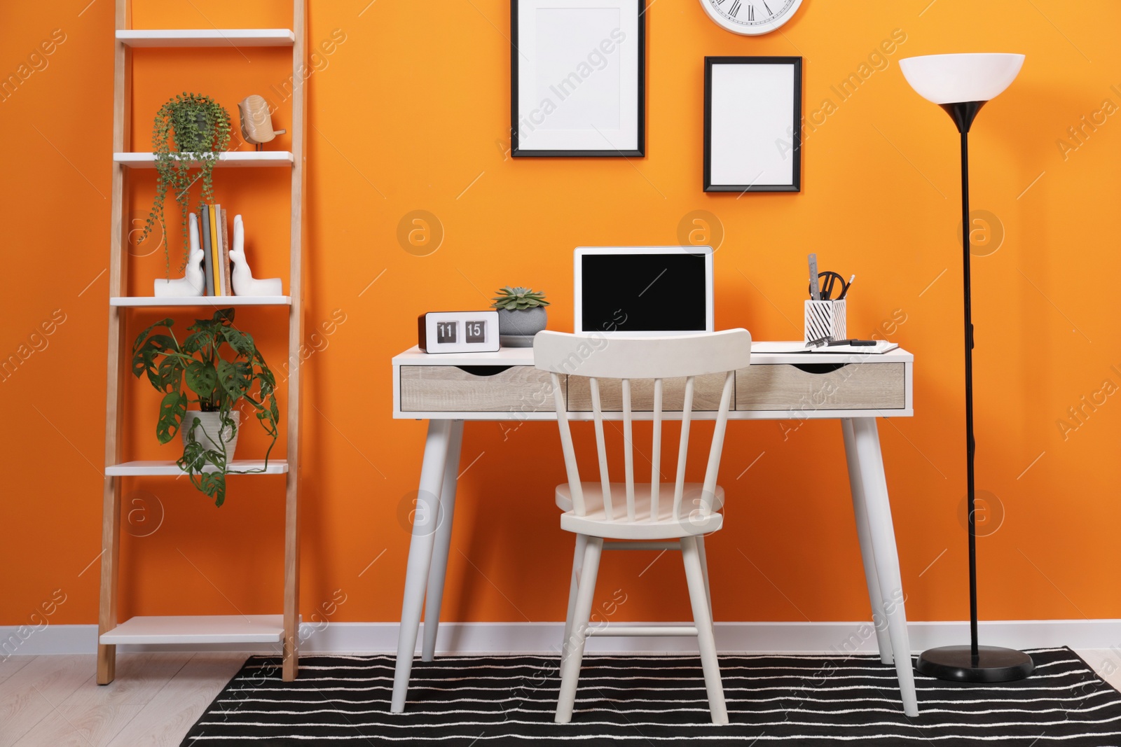 Photo of Workplace with laptop, stationery on desk and chair in home office