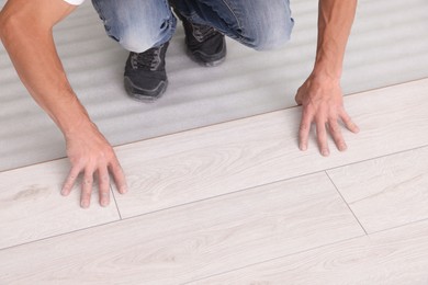 Photo of Man installing new laminate flooring, closeup view