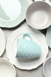 Photo of Beautiful ceramic dishware and cup on light grey table, flat lay