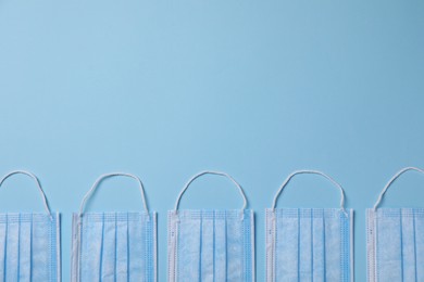 Photo of Protective masks on light blue background, flat lay with space for text. Safety equipment