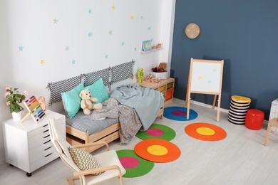 Modern child room interior with comfortable bed and armchair