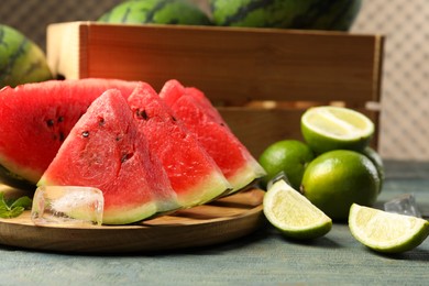 Photo of Slicesdelicious watermelon, limes, ice and mint on light blue wooden table