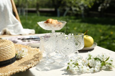 Photo of Beautiful table setting with spring flowers in garden on sunny day