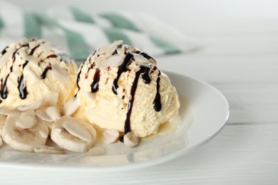 Photo of Delicious banana ice cream with toppings on white wooden table, closeup