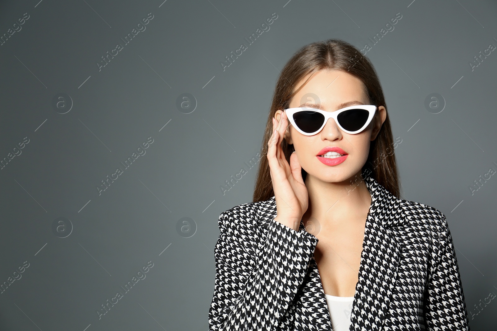 Photo of Young woman wearing stylish sunglasses on grey background. Space for text